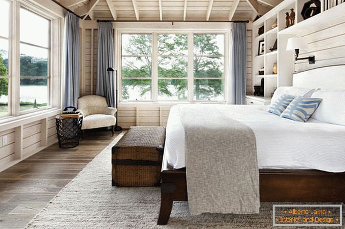Спальня ў скандынаўскім стылі з вялікай двухспальным ложкам з дрэва ў доме французскага бізнэсмэна.