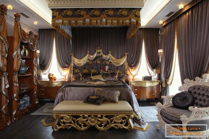 Раскошная спальня У стылі барока. У цэнтры кампазіцыі масіўная ложак з высокім дэкараваным пад галаву.