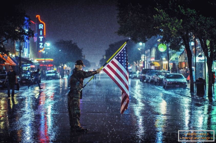 Амерыканскі патрыёт са сьцягамі на вуліцы ў дождж
